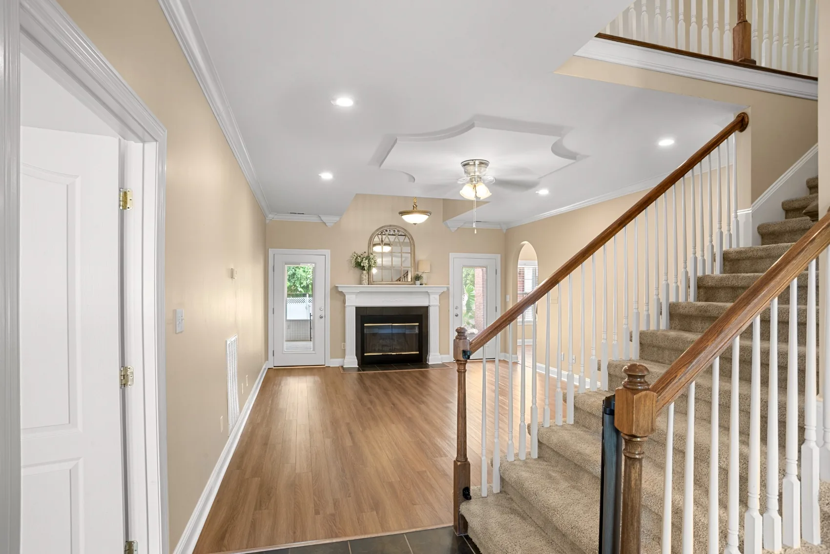 Bright entry hall with staircase and fireplace beyond