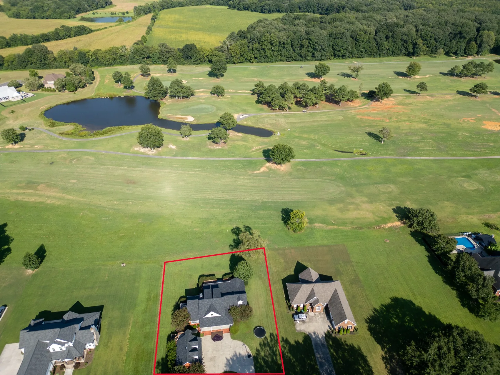 Aerial real estate photograph showing property boundaries beside a golf course