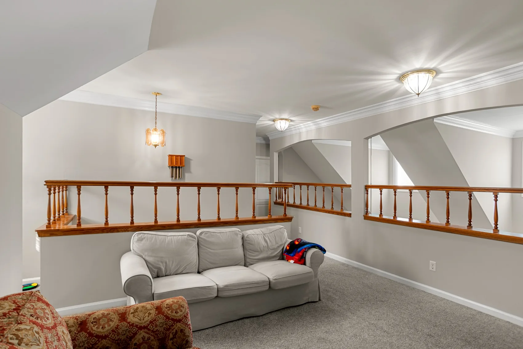 Upstairs sitting area with open railing and vaulted ceiling